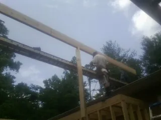 Carpenter setting a ridge beam over a new addition frame — Ice Dam Removal by Roofing Brothers in Upper Marlboro