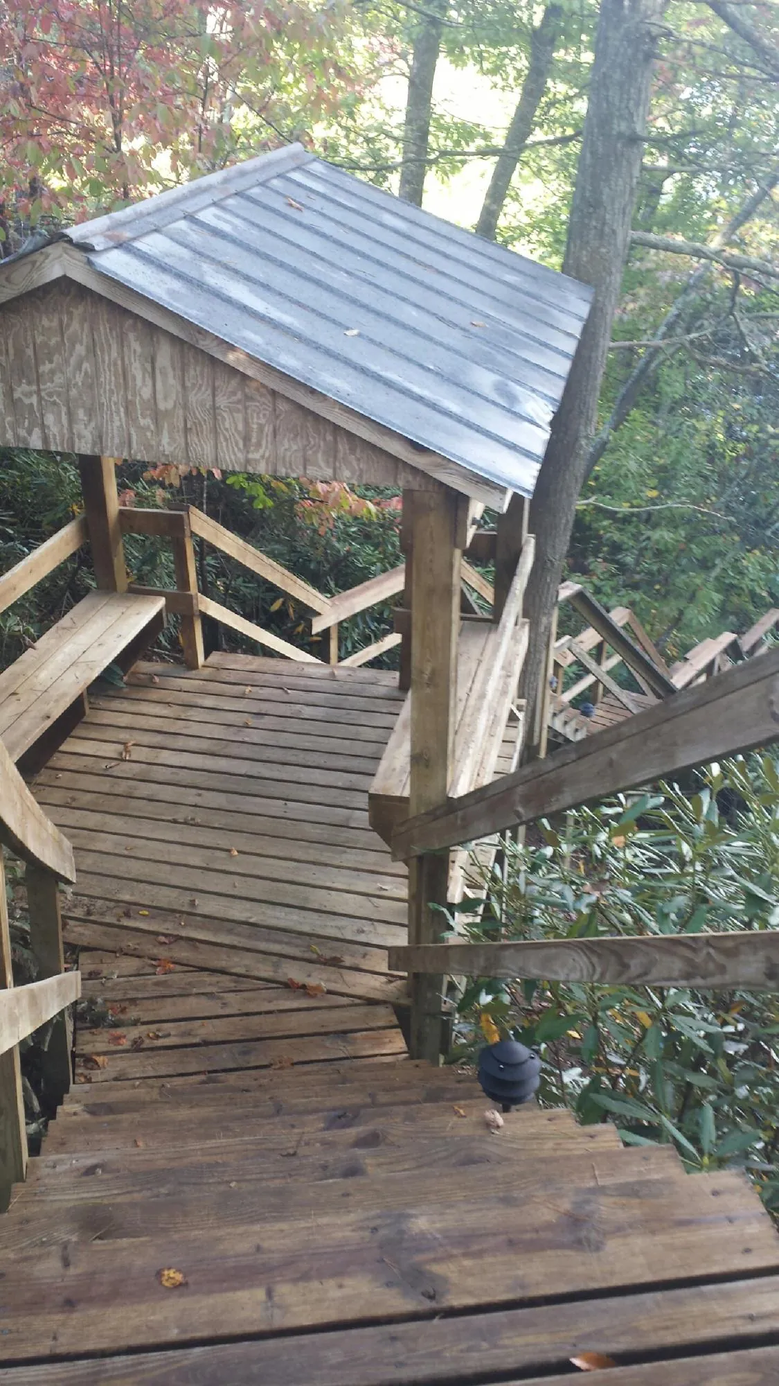 Metal roofed shelter over wooden steps on a wooded walkway — Skylight Repair & Installation work by our crew in Upper Marlboro