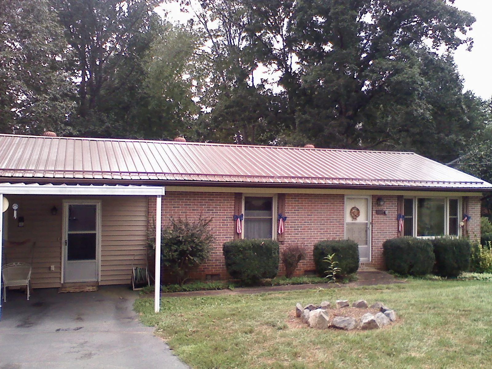 Bronze metal roof and carport on a brick ranch home — Roof Repair work by our crew in Upper Marlboro